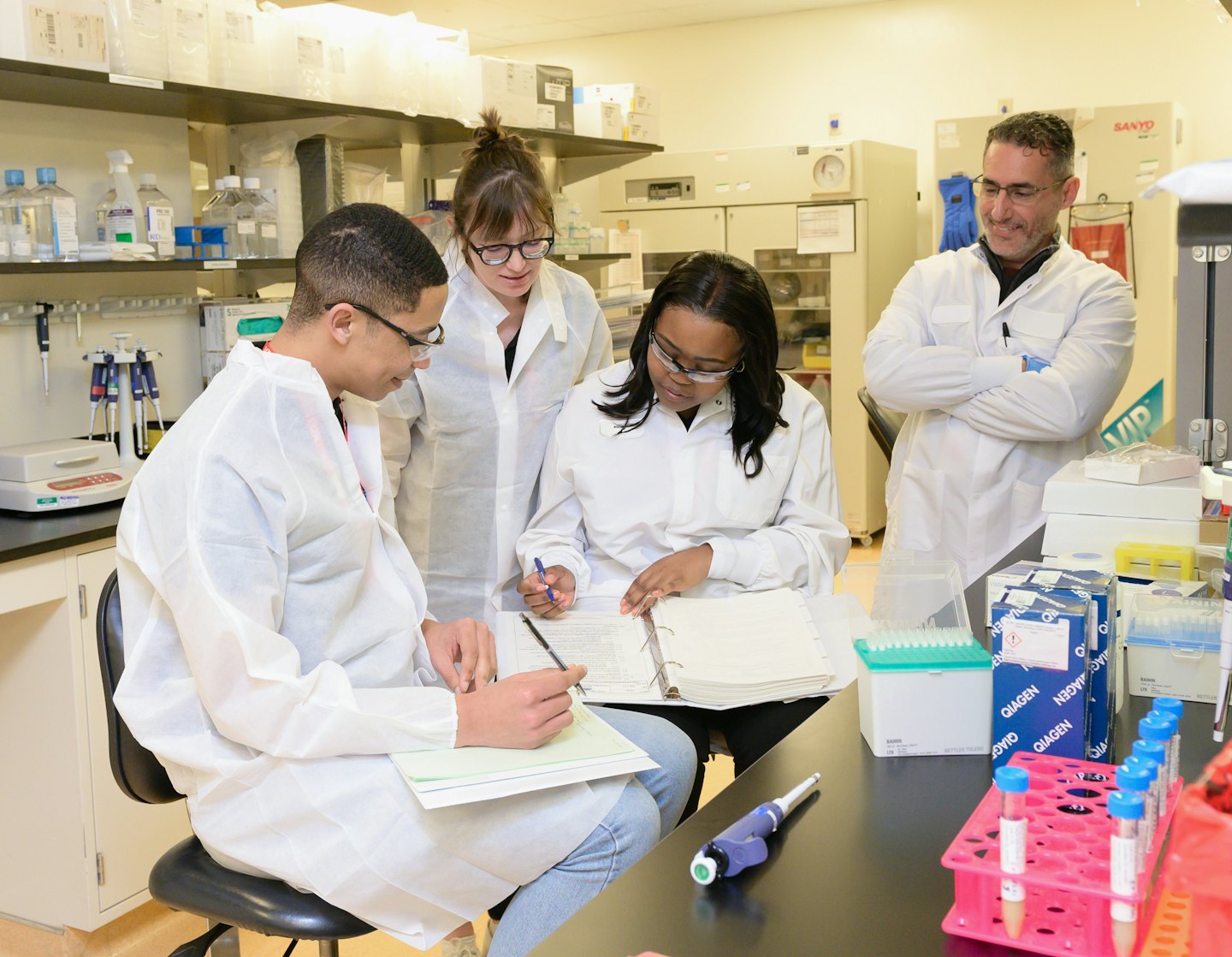 Scienziati collaborano a documenti di ricerca e a un computer portatile in un laboratorio.