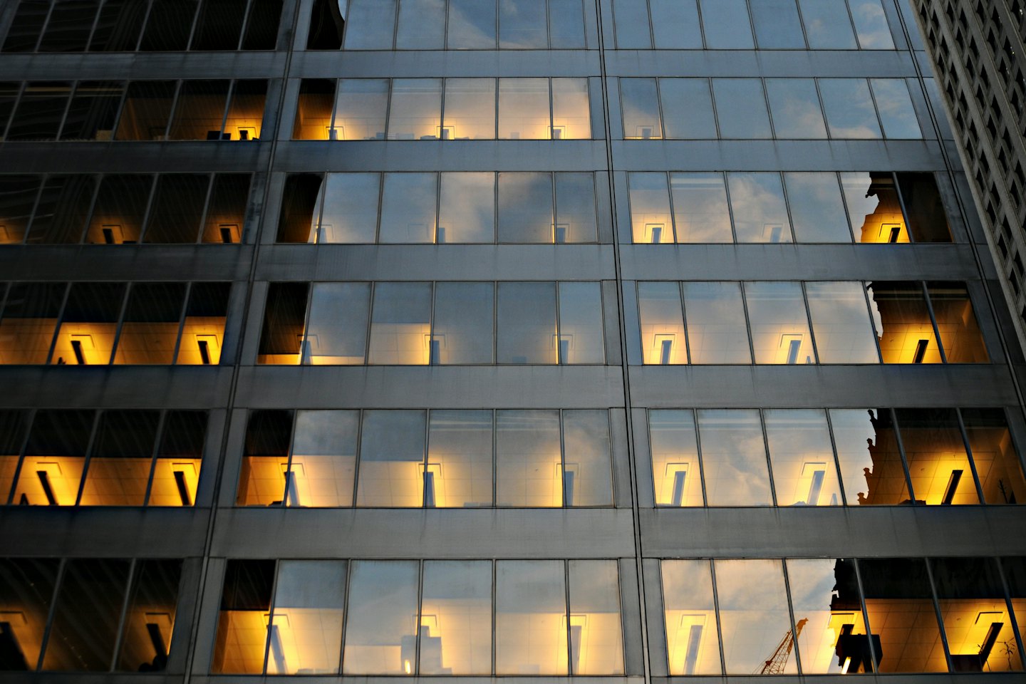 Facciata di un moderno edificio per uffici con finestre illuminate al crepuscolo.