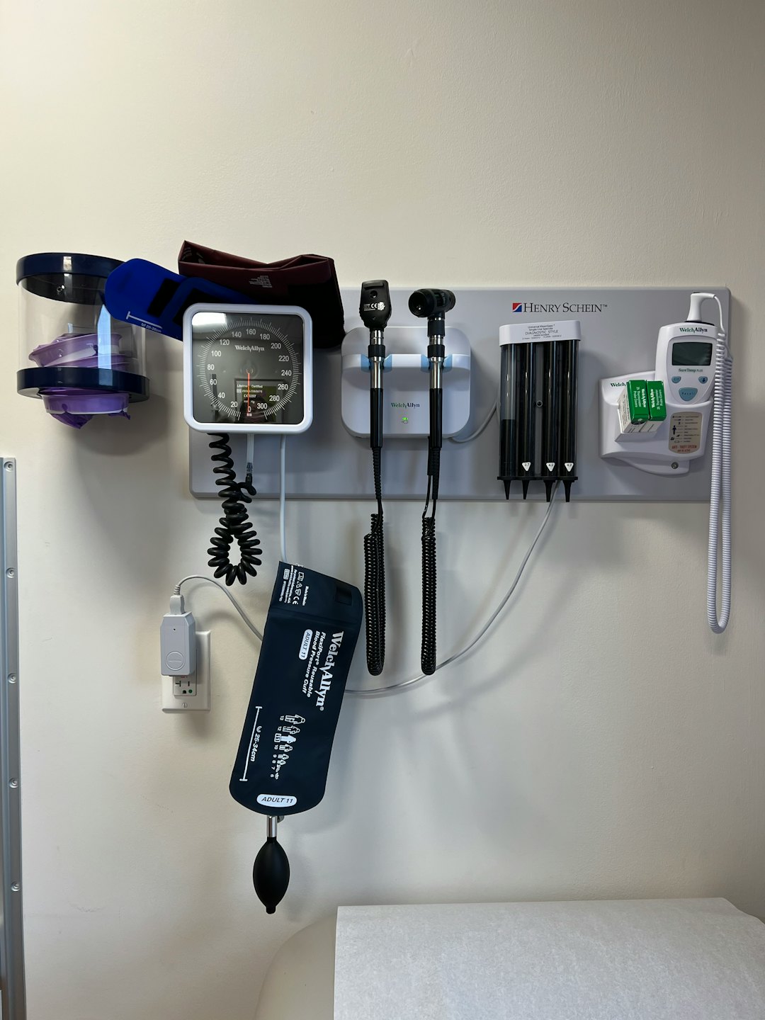 Stazione diagnostica medica a parete con misuratore di pressione sanguigna e strumenti per l'esame.