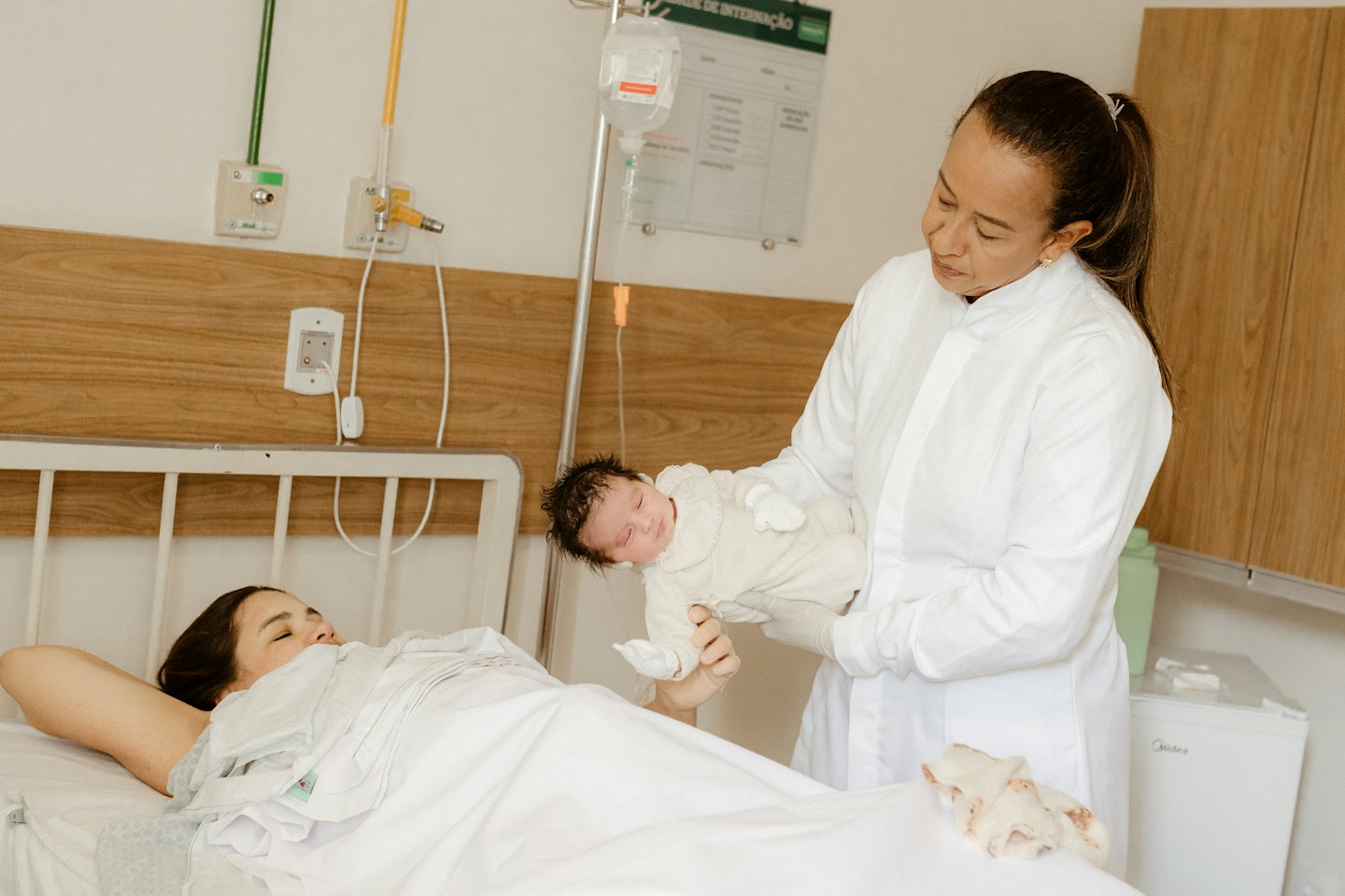 Un operatore sanitario presenta un neonato a una madre.