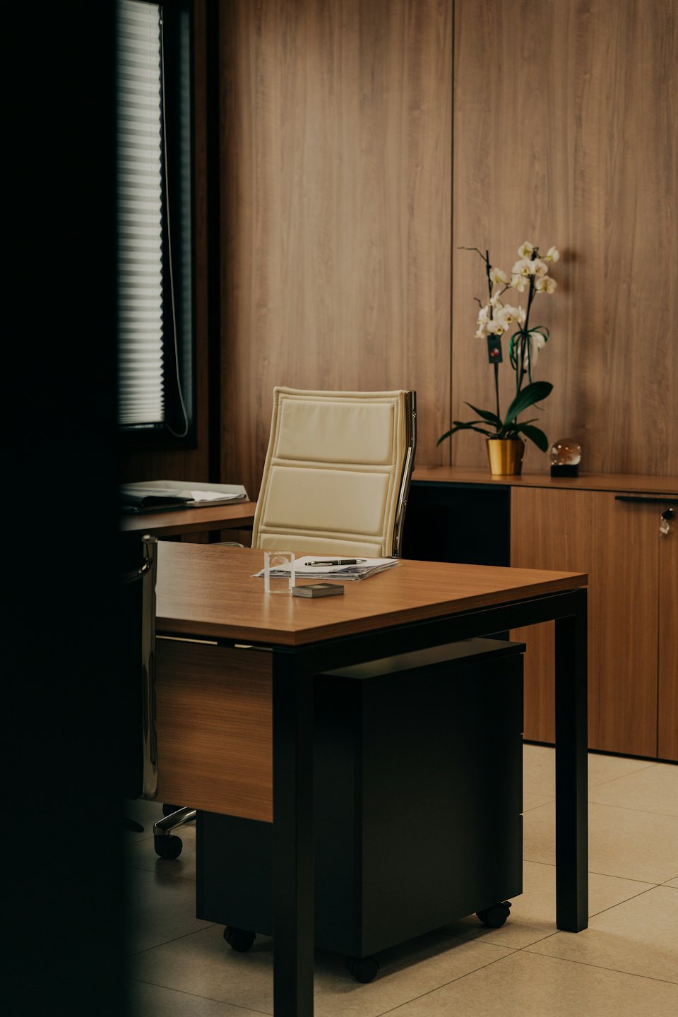 Scrivania e sedia da ufficio moderne con orchidea bianca.