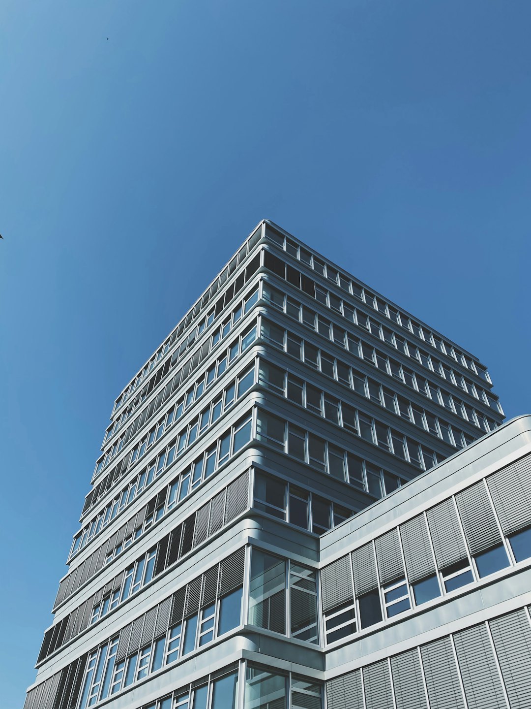 Moderno edificio per uffici con architettura geometrica e facciata in acciaio.