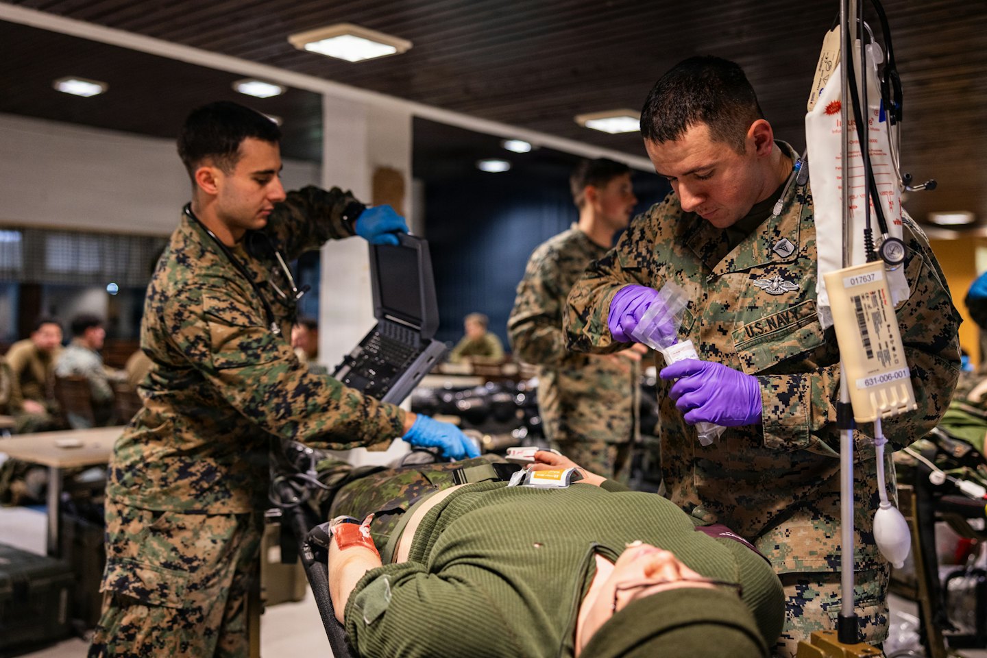 Due tecnici medici preparano l'attrezzatura per un paziente su una barella.