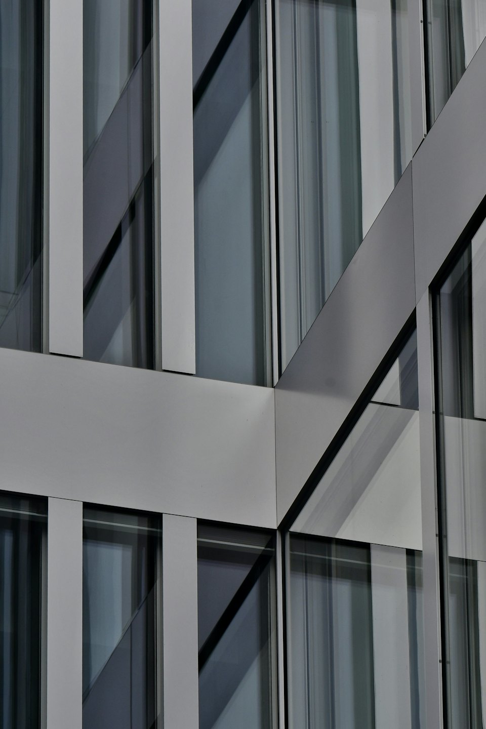 Facciata di un edificio moderno con finestre in vetro e pannelli in metallo grigio.